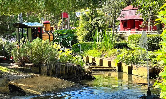 Photo de l'attraction Cocotte Express et son joli parterre de fleurs et de bassin d'eau
